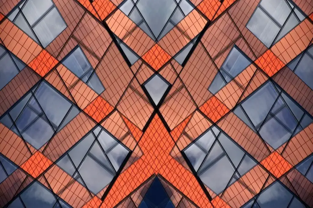 Abstract geometric pattern with intersecting orange and brown lines and reflective surfaces.