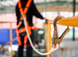 Construction worker tied off to a railing on scaffolding