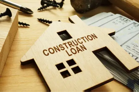 Wooden house model with 'CONSTRUCTION LOAN' text.